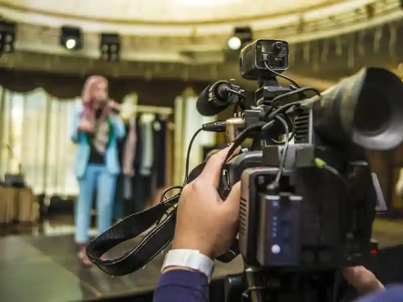 Television camera recording a singing performance.