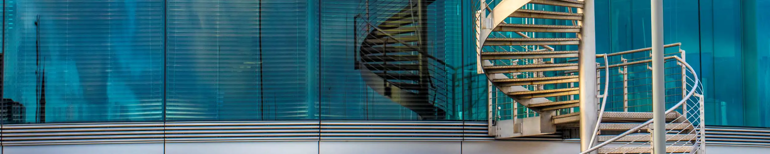 Spiral staircase outside of a modern office building.