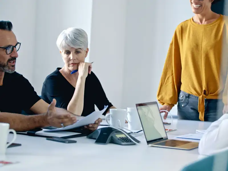 Group of co-workers having a meeting at a large white conference desk